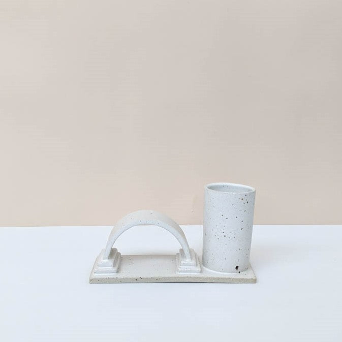 One arch budvase handmade by Oh Hey Grace in Melbourne photographed on a white and cream background. The budvase is finished in a speckled cream glaze.