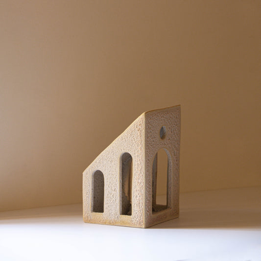 Handmade ceramic sculpture with textural glaze in a lavender, silver, and blush colour. The piece features cut out windows and archways as well as an internal staircase. 